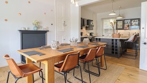 A dining area with a wooden table, leather chairs, and a fireplace. - 5 Porkington Terrace (Barmouth)