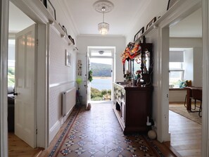Un pasillo con piso estampado, vista al exterior y ventana con vistas al campo.