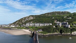 Une ville côtière avec un pont, une plage et des bâtiments construits sur une colline.