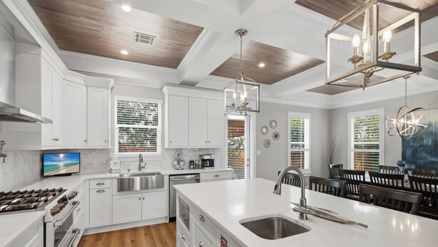 A modern kitchen with white cabinetry, a large island with a sink, stainless steel appliances, and a wooden ceiling. - Bikes, Gated Community, New Rental, Golf Cart, Hot Tub, Close to Beach (Santa Rosa Beach)