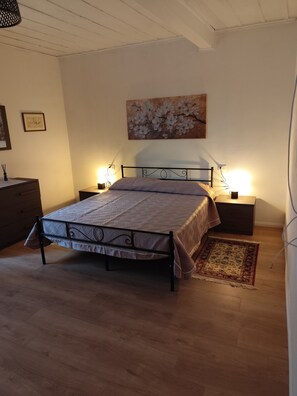 A bedroom with a bed, bedside tables, a nightstand, a dresser, a painting, and a rug. - Casa Yos, 2nd Floor Penthouse. 3 bedrooms for 5 guests (Vallerano)