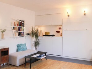 Ein modernes Wohnzimmer mit einer Couch, einem Couchtisch und Bücherregalen.