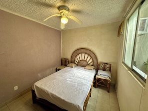 A bedroom with a bed, a ceiling fan, a window, and a nightstand. - 3-bedroom house in safe condo with pool and sun lounger (Acapulco de Juárez)