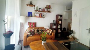 Een woonkamer met een bank, een bijzettafeltje en boekenkasten.