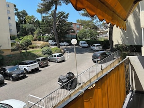 Ein Parkplatz mit mehreren Autos, einer Straßenlaterne und Wohnhäusern im Hintergrund.