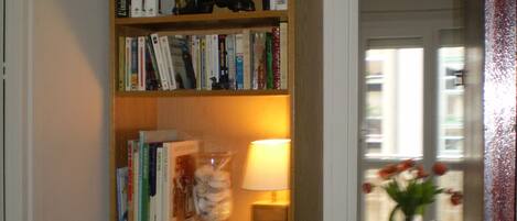 A bookshelf with various books and a decorative elephant figurine.