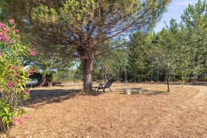A park with a picnic table and benches, surrounded by trees and dry grass. - Charming Villa “Maison Piscine et Nature” with Private Pool, Terraces, and Garden (Le Château-d'Oléron)