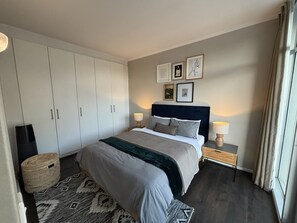 Una camera da letto con un letto, comodini, un armadio e decorazioni alle pareti.