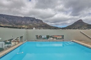 Piscina con vistas a montañas y una ciudad.