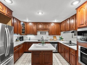 A kitchen with wooden cabinets, stainless steel appliances, and a central island.