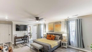 A bedroom with a bed, bedside tables, a desk, a chair, and a TV. - Spacious 3BR 3BA 5 bds Decatur Townhouse (Decatur)