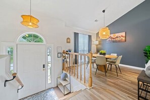 A modern interior with a staircase, dining area, and artwork on the wall. - Two Homes in One · 5BR/4BA · Theater & Game (Gwinnett County)