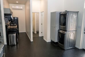 Eine Küche mit Kühlschrank, Backofen, Mikrowelle und einer kleinen Arbeitsfläche mit Toaster.
