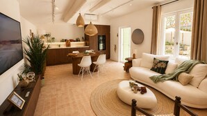Een moderne woonkamer met een televisie, bank en eethoek.