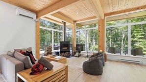 Ein geräumiges Wohnzimmer mit Kamin, großen Fenstern und einer gemütlichen Sitzecke.