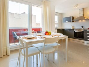 Eine moderne Küche mit Essbereich, einem großen Fenster und einem Balkon.