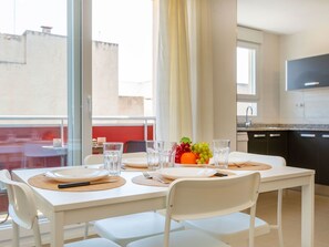 A dining area with a table set for two, a fruit bowl, and a kitchen in the background. - Benicarlo Center by Interhome (Benicarló)