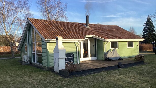 A single-story house with a chimney, a front porch, and a small deck. - 4 Star Holiday Home in Stubbekobing (Stubbekobing)