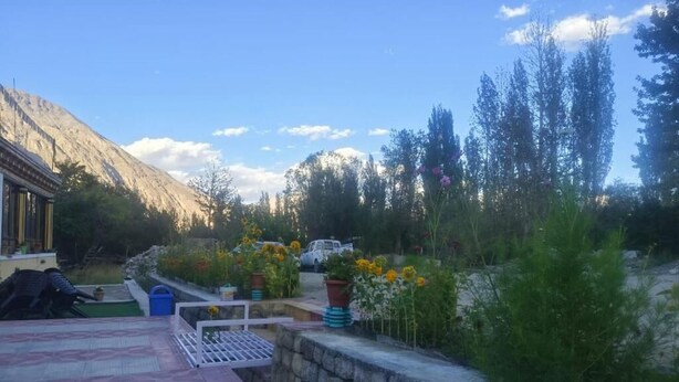 A courtyard with a stone wall, a small pool, and potted plants. - Rabgais Nubra Retreat (Hunder)