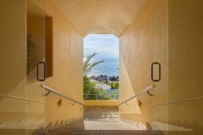 Eine Treppe führt zu einem Balkon mit Blick aufs Meer.
