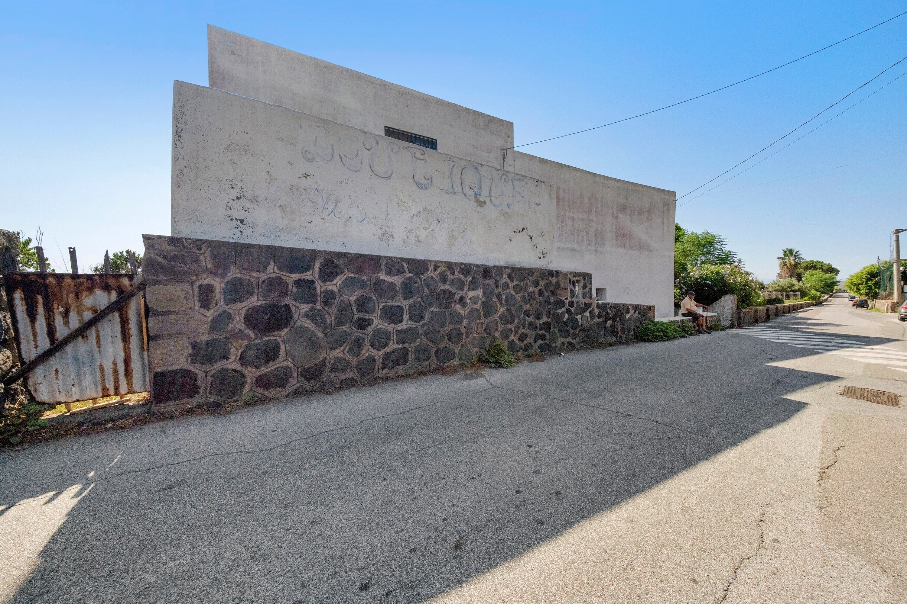 Un edificio con una parete in pietra e un tetto piatto.