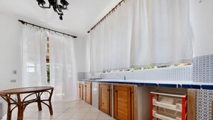 A kitchen with a dining table, wooden cabinets, and a tiled backsplash.