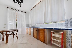 Una cocina con una mesa de comedor, armarios de madera y un revoque de azulejos.