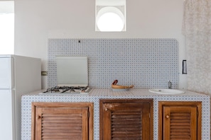 A kitchen with patterned backsplash, a gas stove, a sink, and wooden cabinets. - Apartment 'Quadara - Sul Rifugio' with Sea View, Private Terrace and Shared Garden (Lingua)
