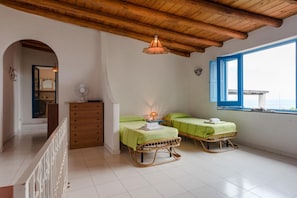 A room with two green beds, a wooden dresser, a fan, and a window with a view. - Apartment 'Quadara - Sul Rifugio' with Sea View, Private Terrace and Shared Garden (Lingua)