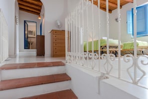 A staircase leading to a bedroom with a bed, a dresser, and a fan. - Apartment 'Quadara - Sul Rifugio' with Sea View, Private Terrace and Shared Garden (Lingua)