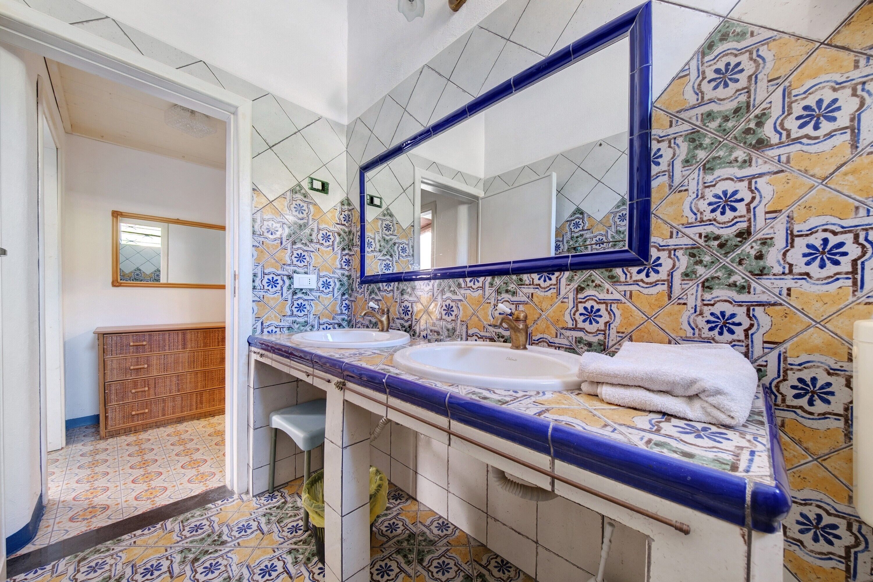 A bathroom with two sinks, a mirror, and a tiled floor.