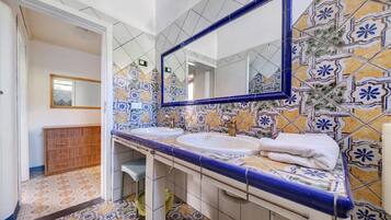 A bathroom with two sinks, a mirror, and a tiled floor.