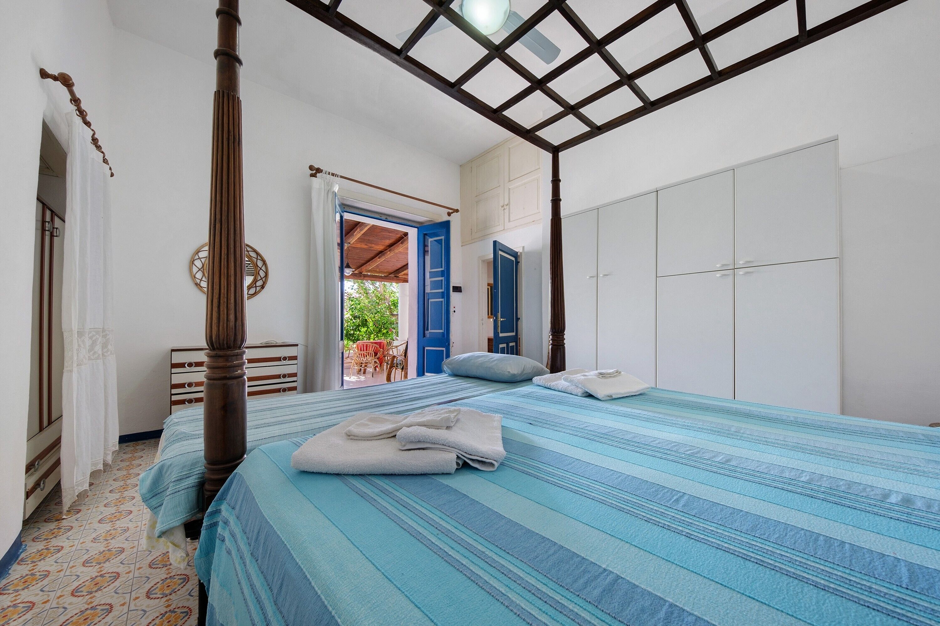 Ein Schlafzimmer mit einem Bett, einem Kleiderschrank und einem Badezimmer mit Toilette und Waschbecken.