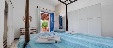 Un dormitorio con cama, armario y baño que incluye inodoro y lavabo.