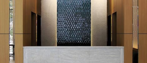 A modern interior with a textured wall, a wooden panel design, and a textured counter.