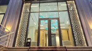 A hotel entrance with a grand staircase leading up to a glass door. - PAZIRO HOTEL (Dushanbe)