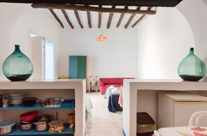 Une pièce avec un plafond en bois, un canapé rouge et une porte blanche.