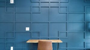 A blue wall with a geometric pattern, a wooden table, and a brown chair. - Hyde Park Deluxe private residence (Tampa)
