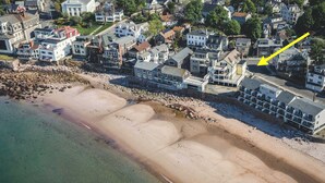 Vista aérea de una zona residencial costera con casas a lo largo de la playa.
