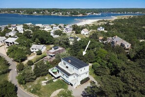 Vista aérea de una zona residencial con casas, una playa y una masa de agua.