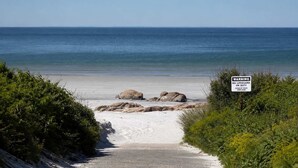 A beach with a warning sign, a clear sky, and a calm sea. - Stay at Wingaersheek (Gloucester)