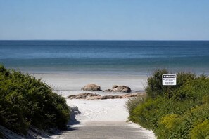 A beach with a warning sign, a clear sky, and a calm sea. - Stay at Wingaersheek (Gloucester)