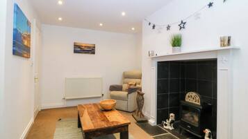A living room with a fireplace, a sofa, a coffee table, and a painting on the wall.