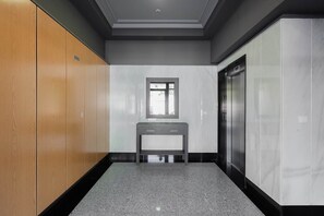 A hallway with a wooden wardrobe, a small table, a window, and an elevator. - Ardantza Bidea - baskeyrentals (Zumaia)