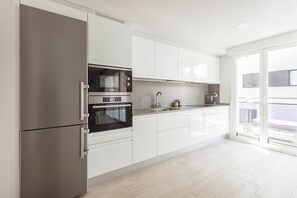 A modern kitchen with a built-in oven, a stainless steel refrigerator, and a large window. - Ardantza Bidea - baskeyrentals (Zumaia)