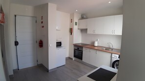 Eine kleine Küche mit Mikrowelle, Backofen und Spüle.