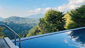 A swimming pool with a view of a mountainous landscape and a clear sky.