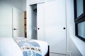 A bedroom with a bed, a wardrobe, and a window. - Revy Rendezvous | Private Hot Tub & Mountain Views (Revelstoke)