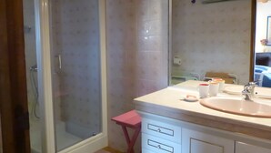 Ein Badezimmer mit Dusche, Waschbecken und Spiegel.