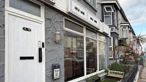 A townhouse with a white door, a mailbox, and a sign indicating 'Home Love.' - Suncrest Hotel (Blackpool)